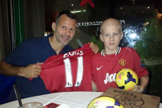 Ryan Giggs handing over a signed shirt and footballs to Levi